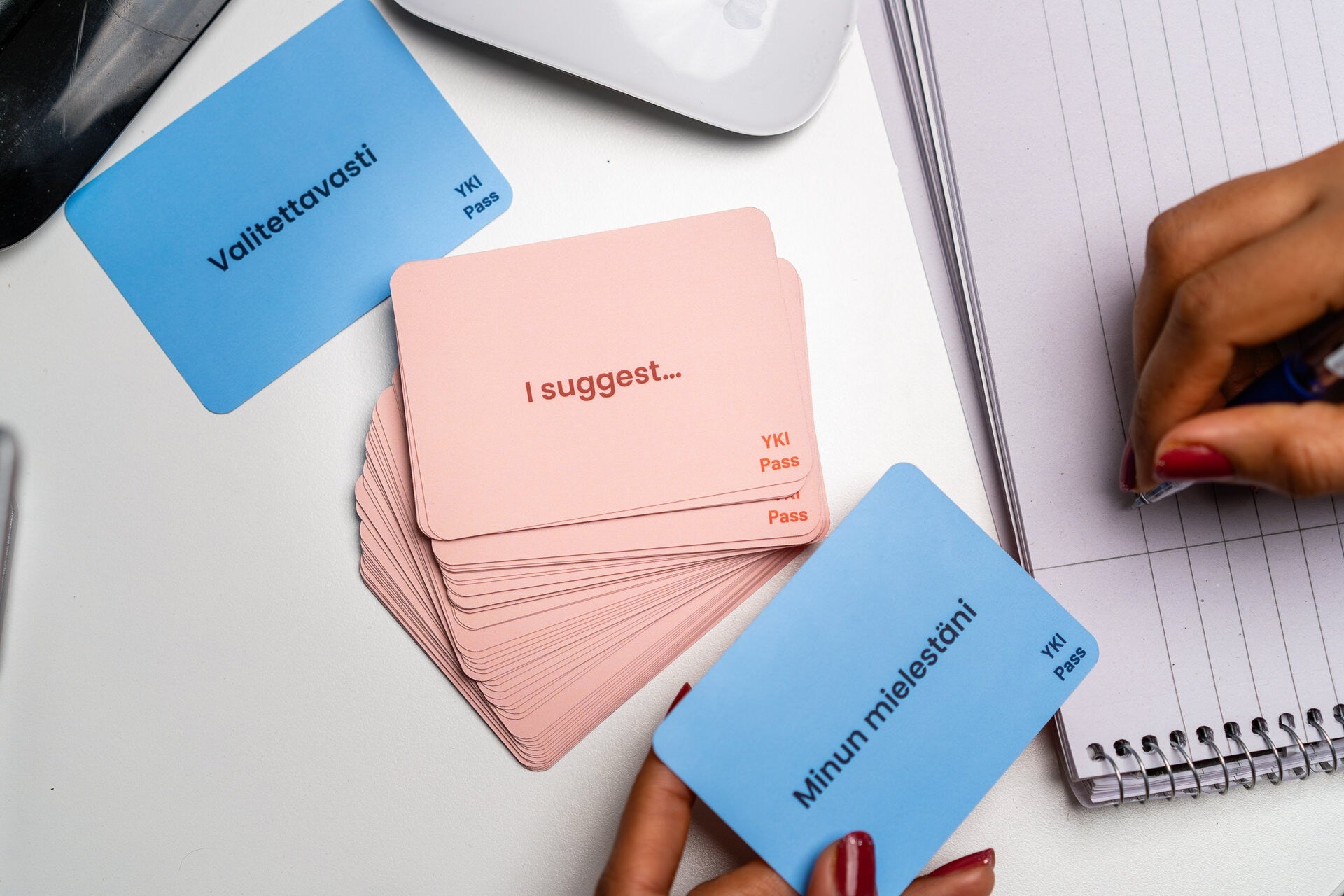 YKI Flashcards are on the table and someone is writing notes.