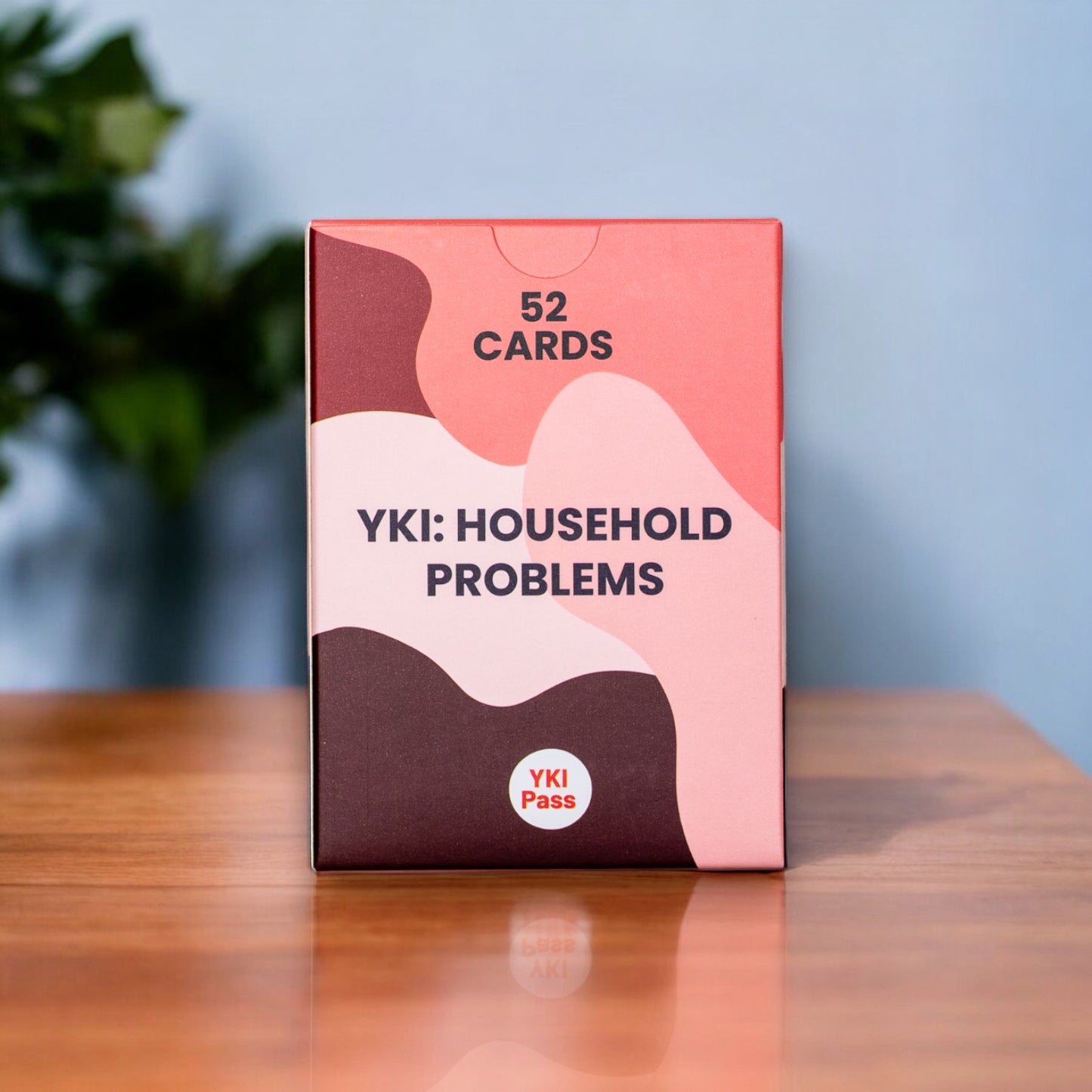 YKI Household problems flashcards box on a wooden table.