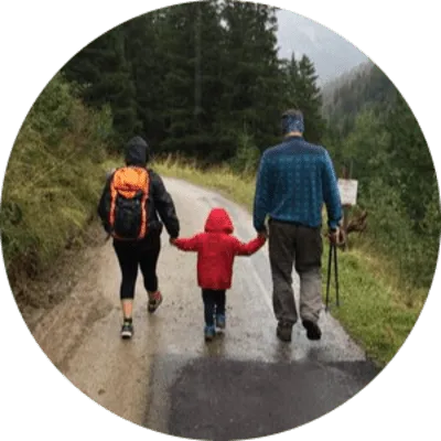 A family enjoying a hike in a Finnish forest, surrounded by breathtaking scenery and lush greenery.