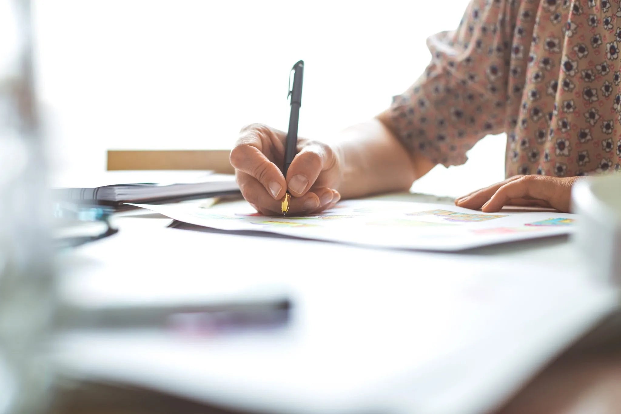 Image of a person writing on a paper. 